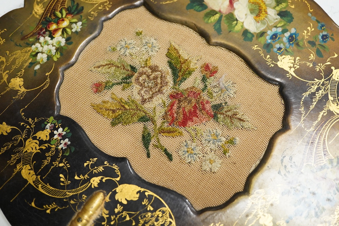 A pair of early Victorian papier maché hand screens, each with embroidered with cross stitched flowers, 41cm in length